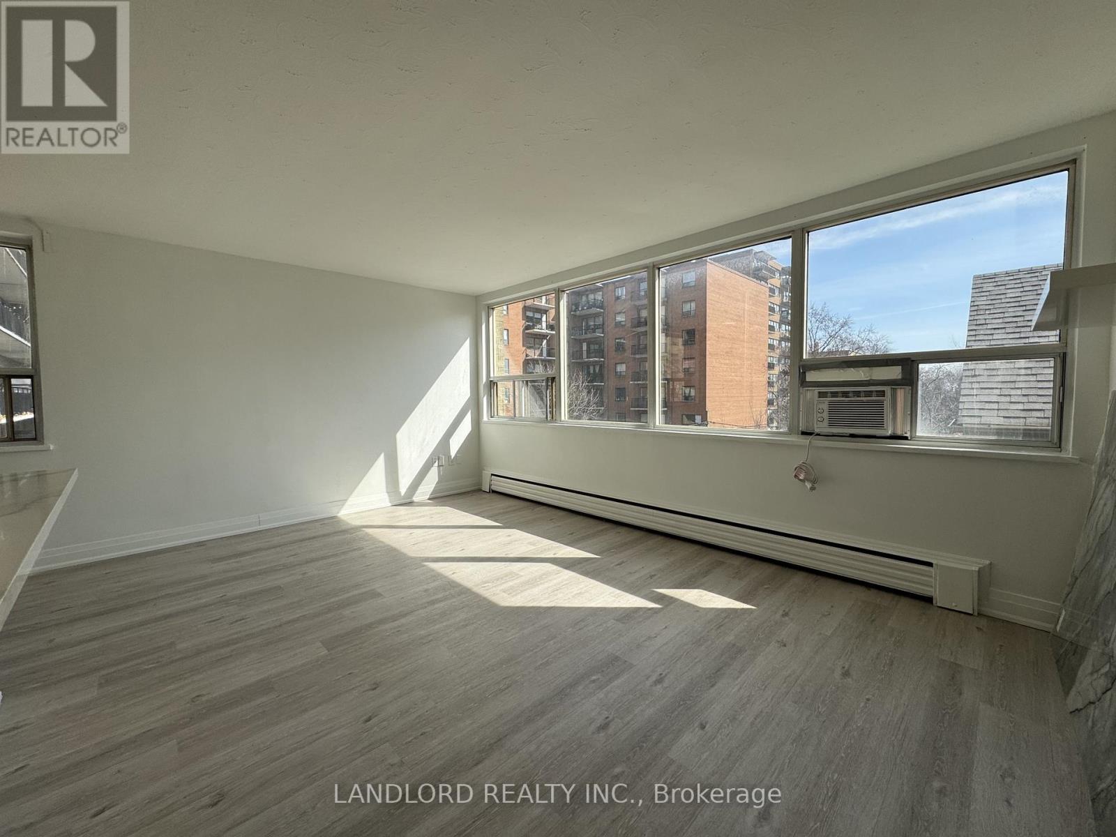 A room with a large window and wooden flooring.