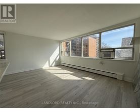 A room with a large window and wooden flooring.