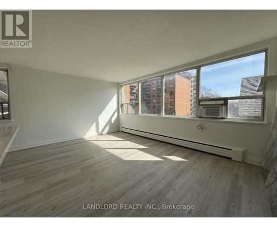 A room with a large window and wooden flooring.