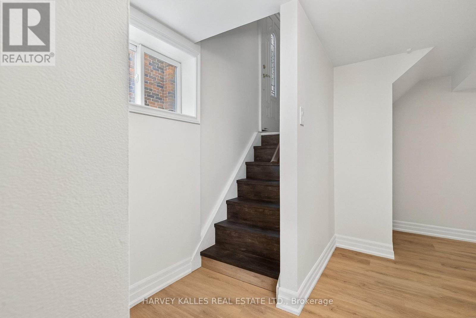 A staircase in a house with a white wall and wooden steps.