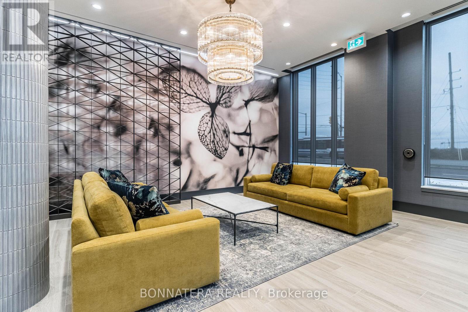 A living room with a yellow couch and a chandelier.