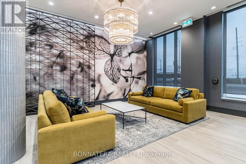A living room with a yellow couch and a chandelier.