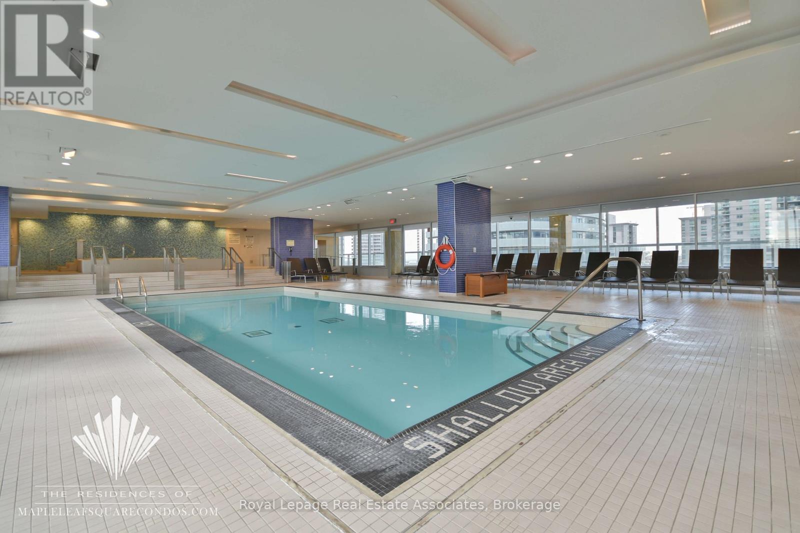 A large indoor swimming pool with a logo on the bottom left.