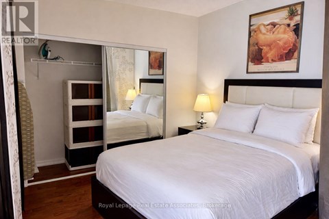 A bedroom with a large bed and a mirror on the wall.