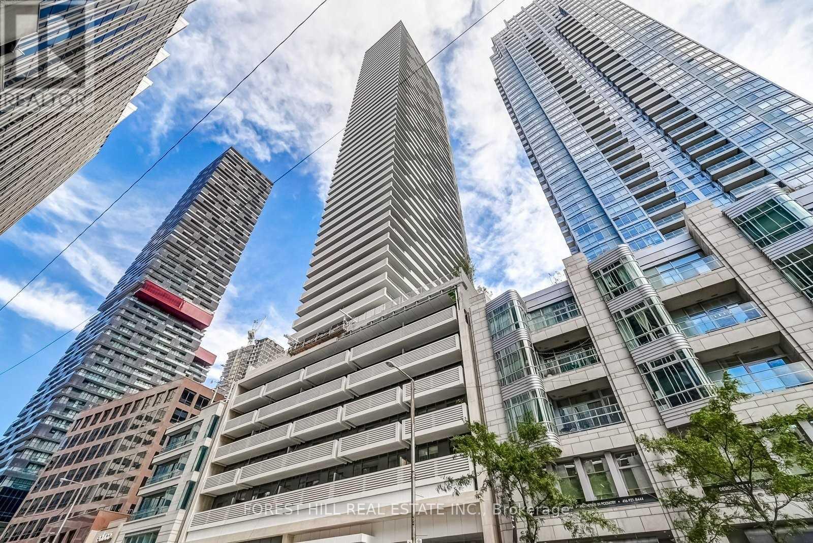 A tall building with the words "Forest Hill Residential Inc." on its facade is seen from a low angle.