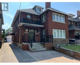A red brick house with a black iron railing on the balcony.