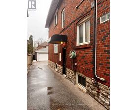 A red brick building with a black awning and a white garage door.