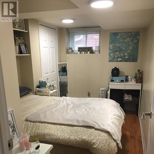A bedroom with a bed, desk, and window.