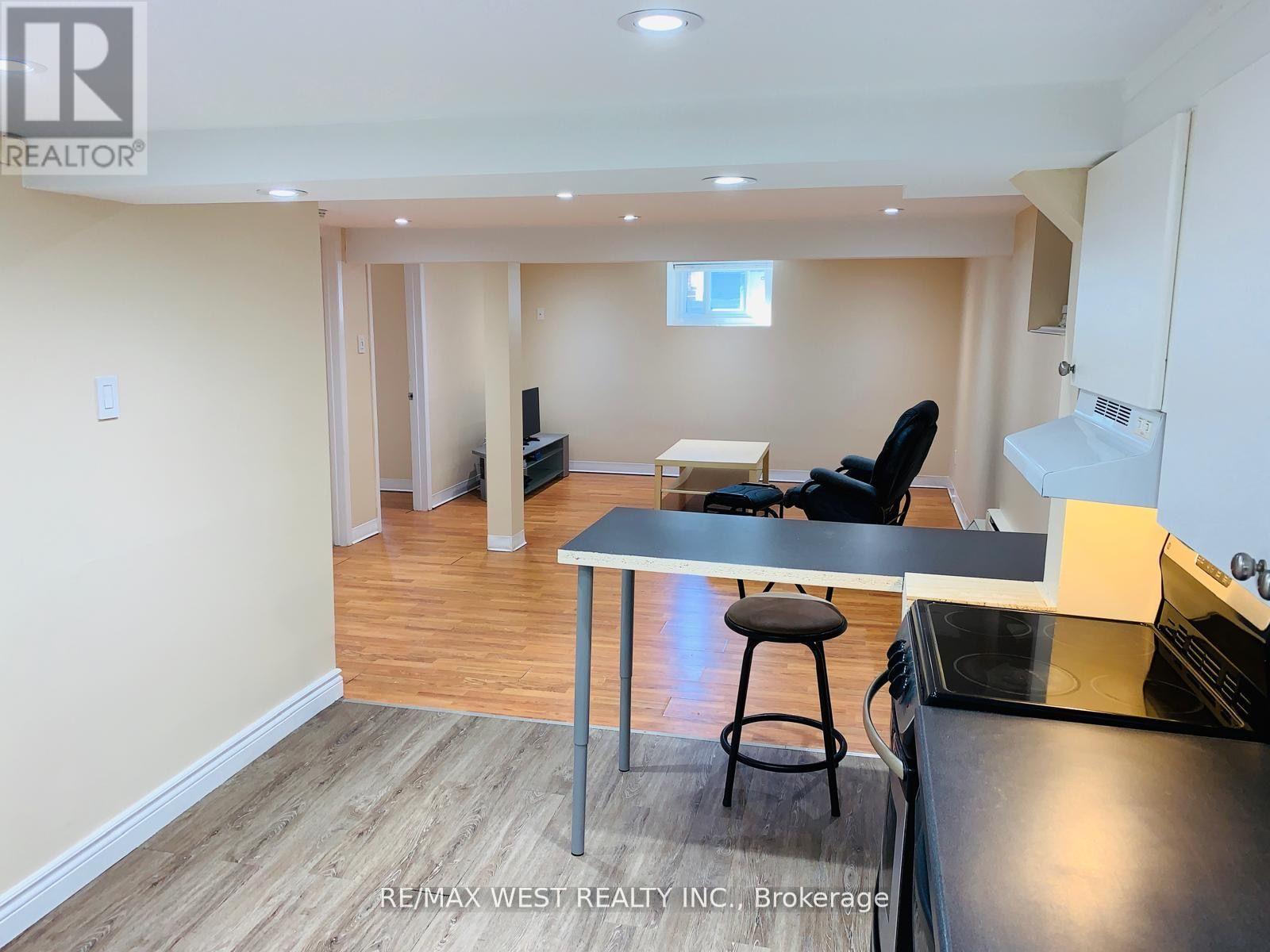 A kitchen area with a table and chairs in a room with wooden flooring.