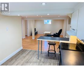 A kitchen area with a table and chairs in a room with wooden flooring.
