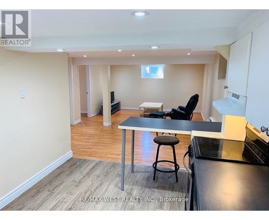 A kitchen area with a table and chairs in a room with wooden flooring.