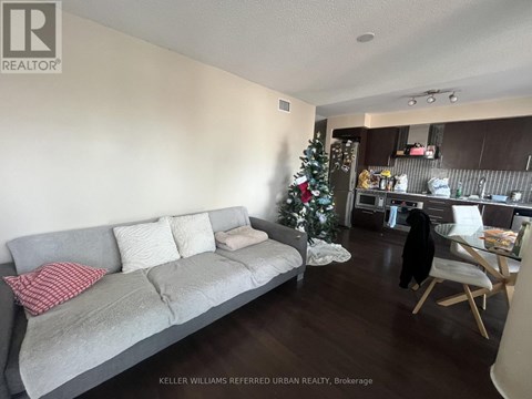 A living room with a grey couch and a Christmas tree.