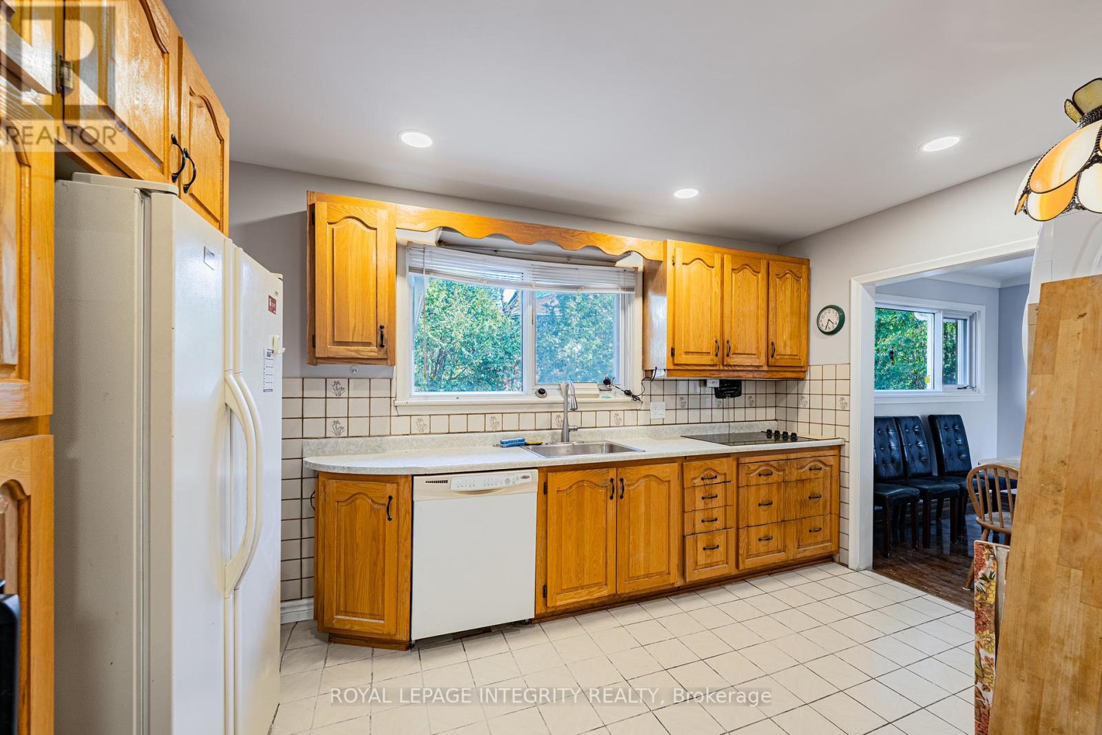 A kitchen with wooden cabinets and a white refrigerator.