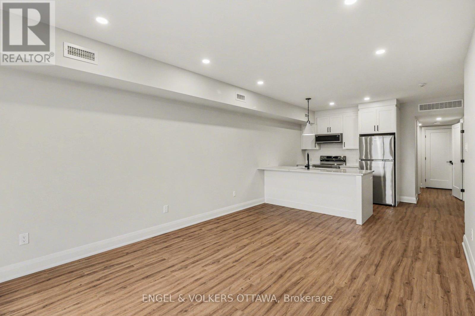 A large, empty room with wooden floors and white walls.