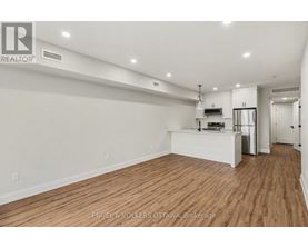 A large, empty room with wooden floors and white walls.