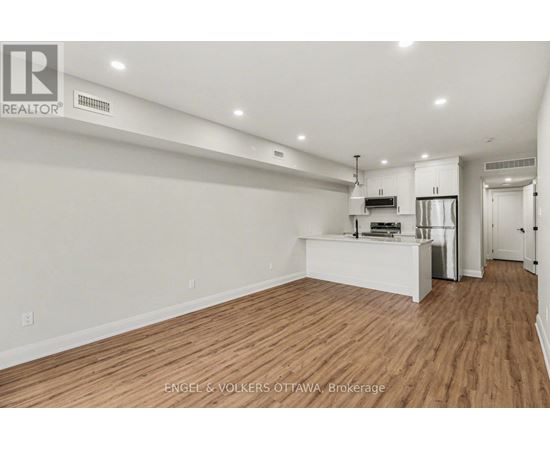 A large, empty room with wooden floors and white walls.