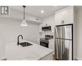 A modern kitchen with a stainless steel refrigerator and a marble countertop.