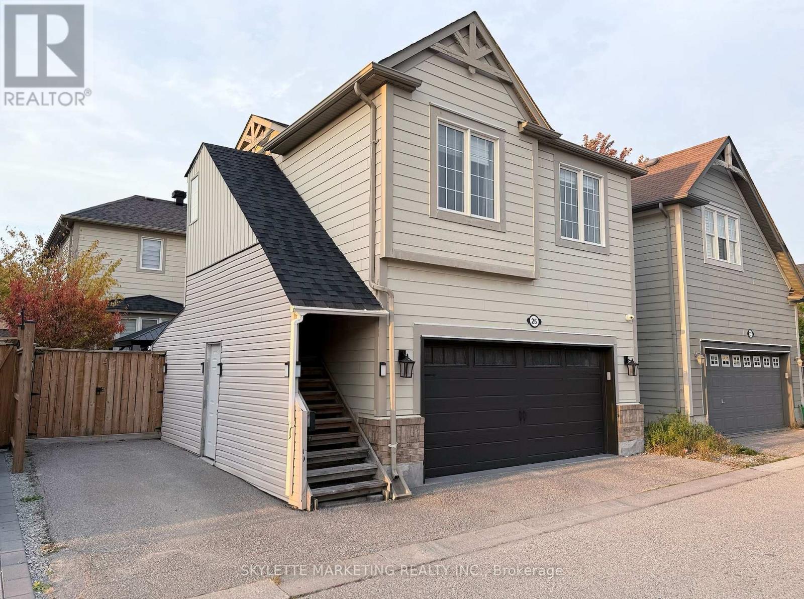 A two-story house with a garage and a staircase leading to the entrance.