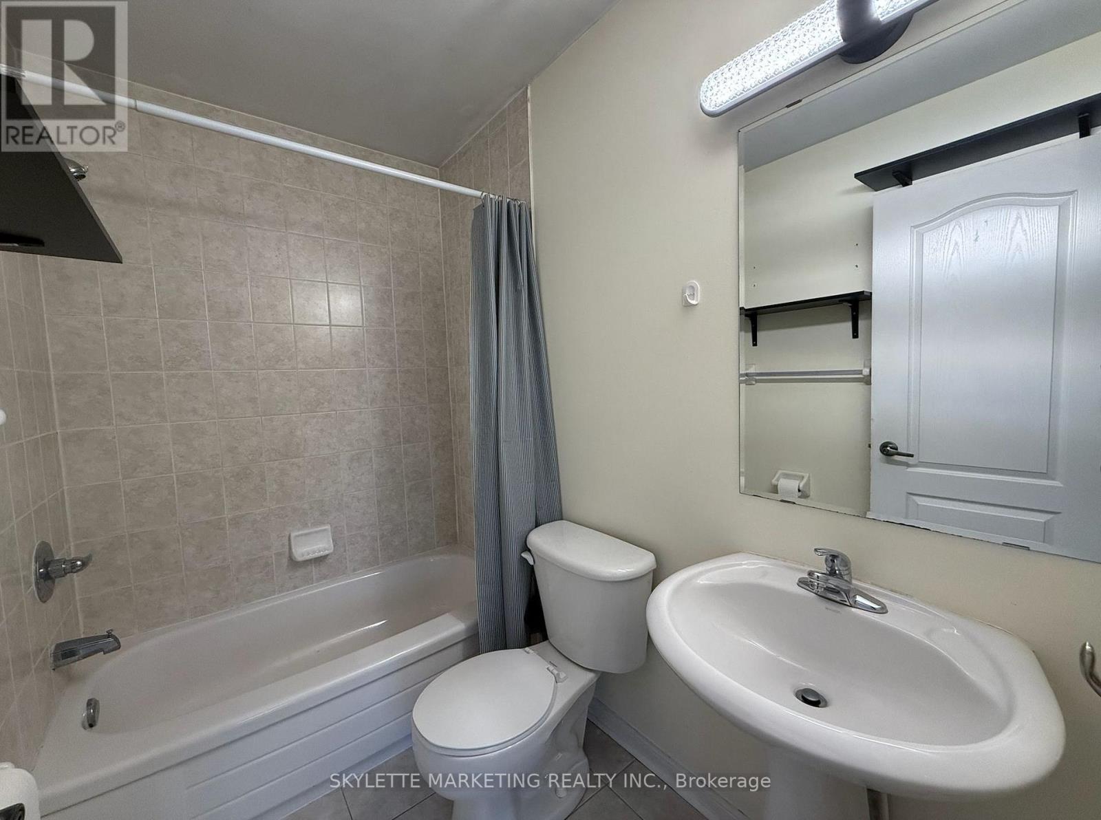 A bathroom with a toilet, sink, and bathtub.