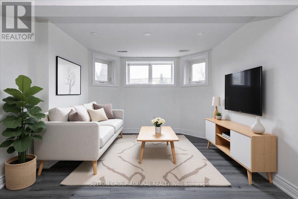 A living room with a white couch, a wooden coffee table, and a flat-screen TV mounted on the wall.