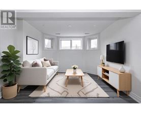 A living room with a white couch, a wooden coffee table, and a flat-screen TV mounted on the wall.