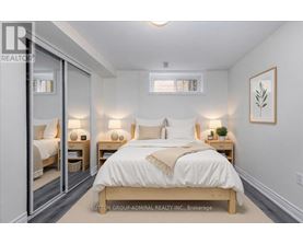 A bedroom with a large bed and two nightstands with lamps.