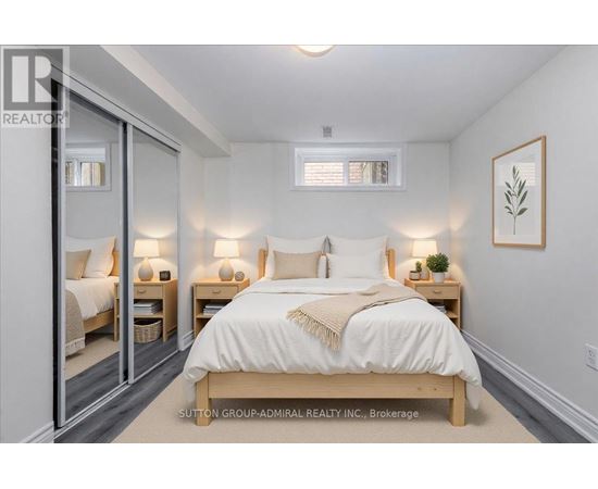 A bedroom with a large bed and two nightstands with lamps.