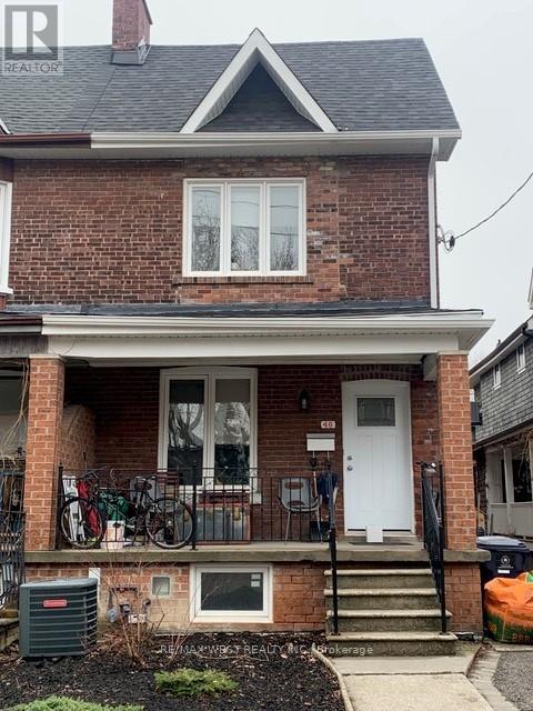 A brick house with a white door and windows.