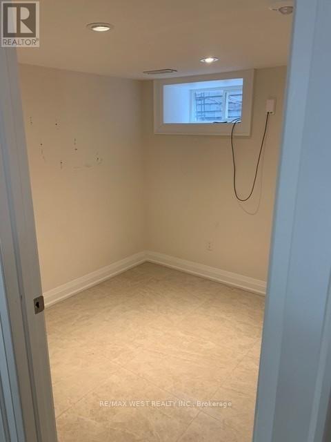 A room with a window and a white wall.