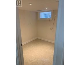 A room with a window and a white wall.