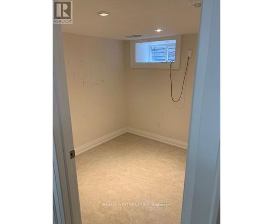 A room with a window and a white wall.