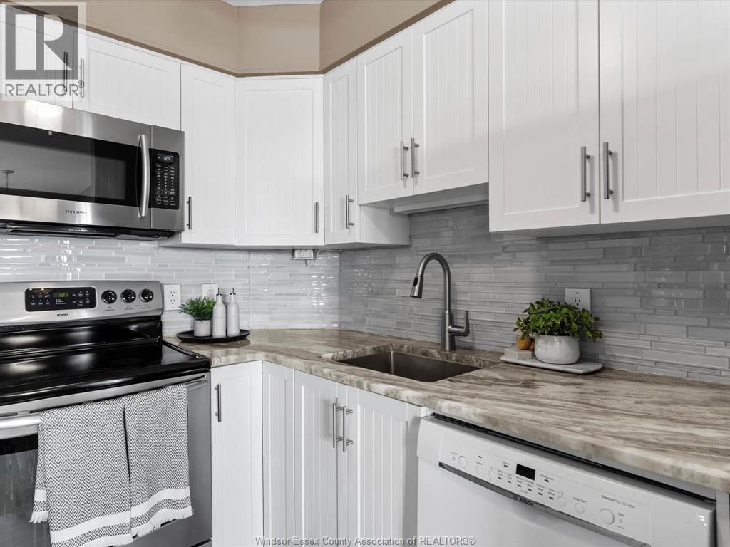 A kitchen with white cabinets and a stove top oven.