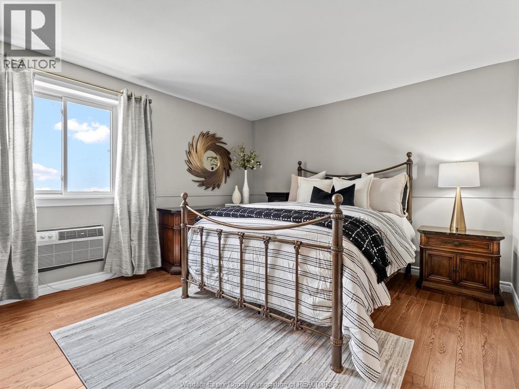 A bedroom with a large bed and a window with curtains.