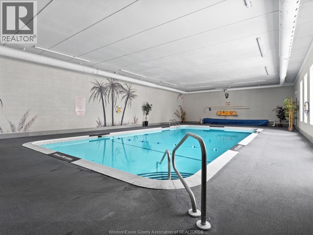 A large indoor swimming pool with a diving board.
