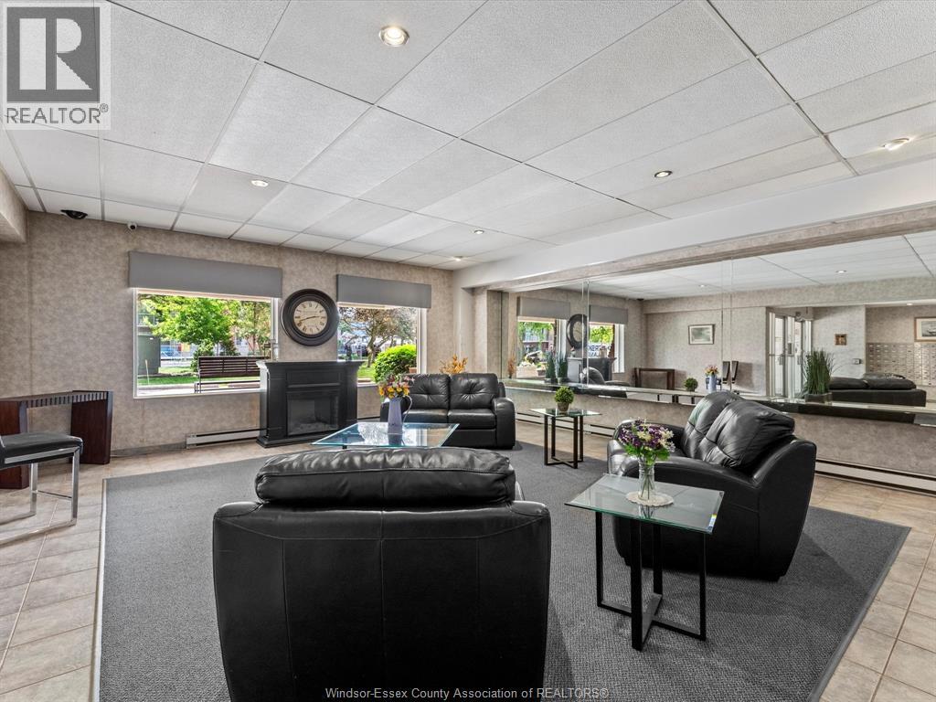 A living room with black furniture and a large window.