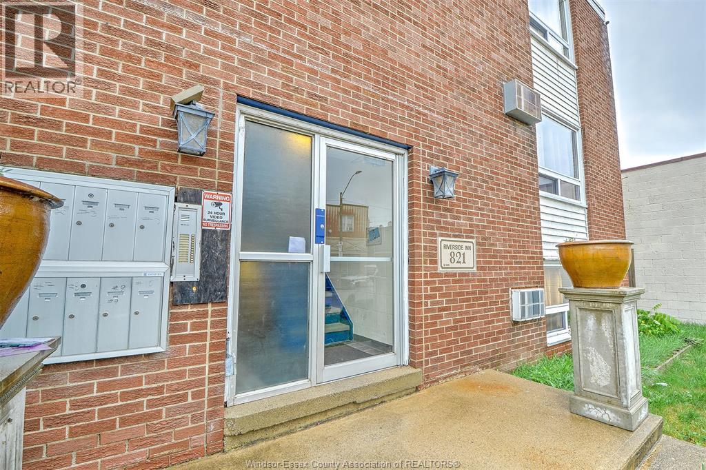 A brick building with a glass door and a sign that says REALTOR.