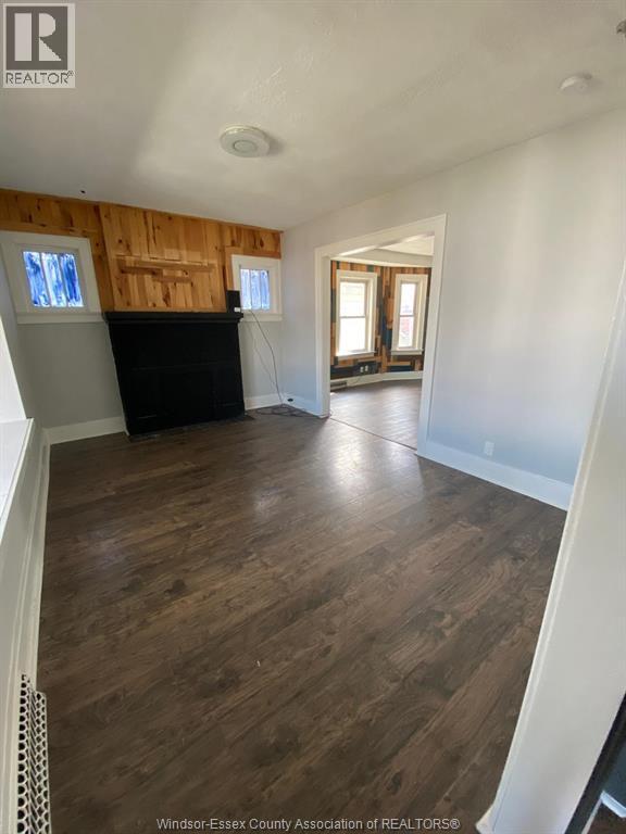 A room with wooden floors and a black piano.