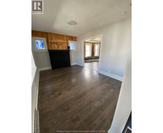 A room with wooden floors and a black piano.