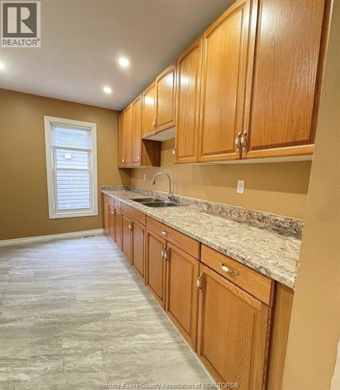 A kitchen with wooden cabinets and granite countertops.