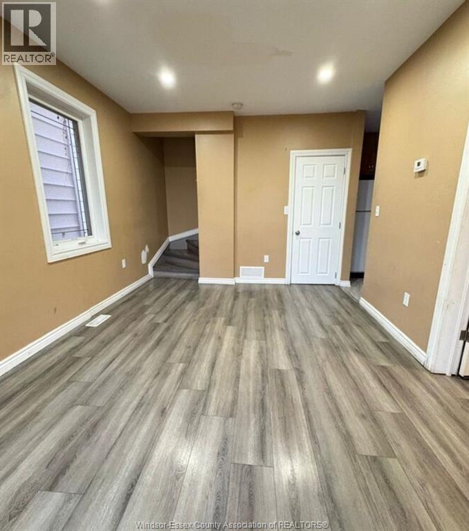 A room with wooden flooring and a white door.