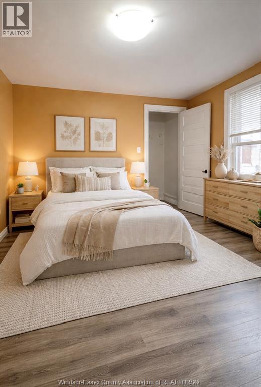 A bedroom with a large bed, two nightstands, and a window.
