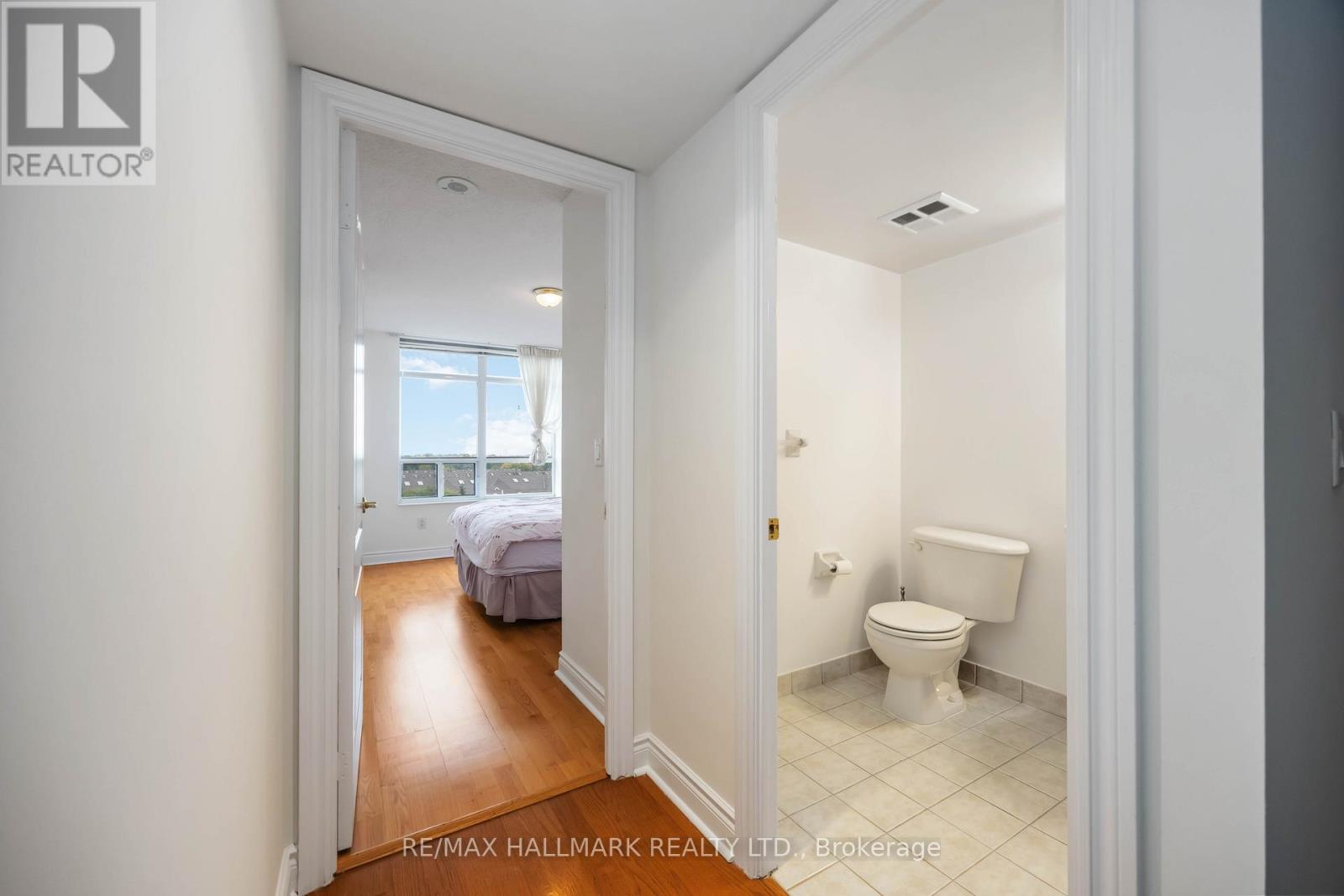A bedroom with a bed and a toilet in a hallway.