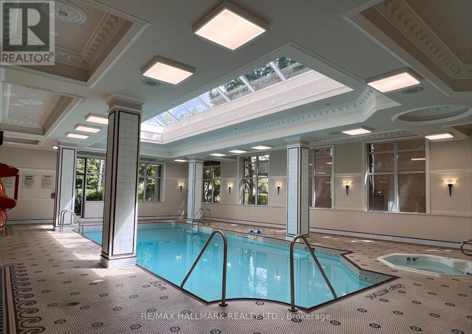 A large indoor swimming pool with a skylight above it.
