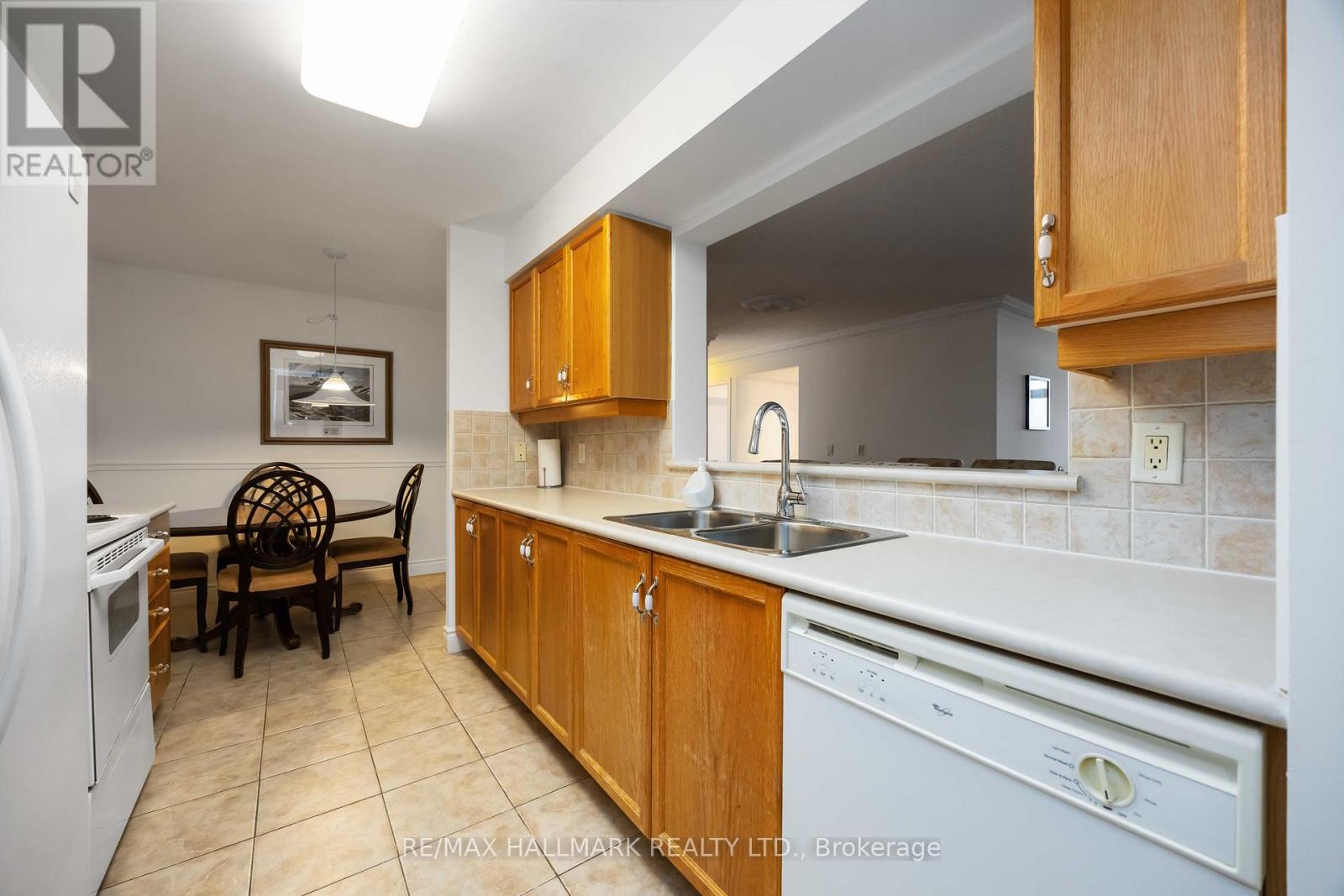 A kitchen with wooden cabinets and a white dishwasher.