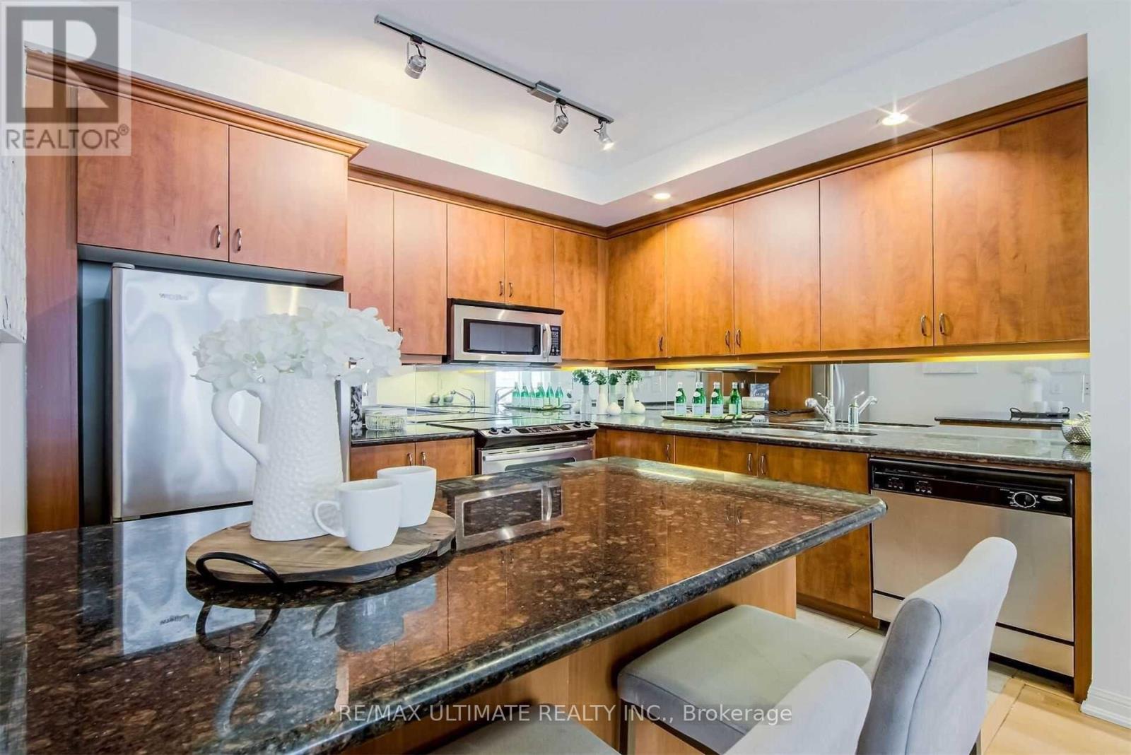A kitchen with a granite countertop and wooden cabinets.