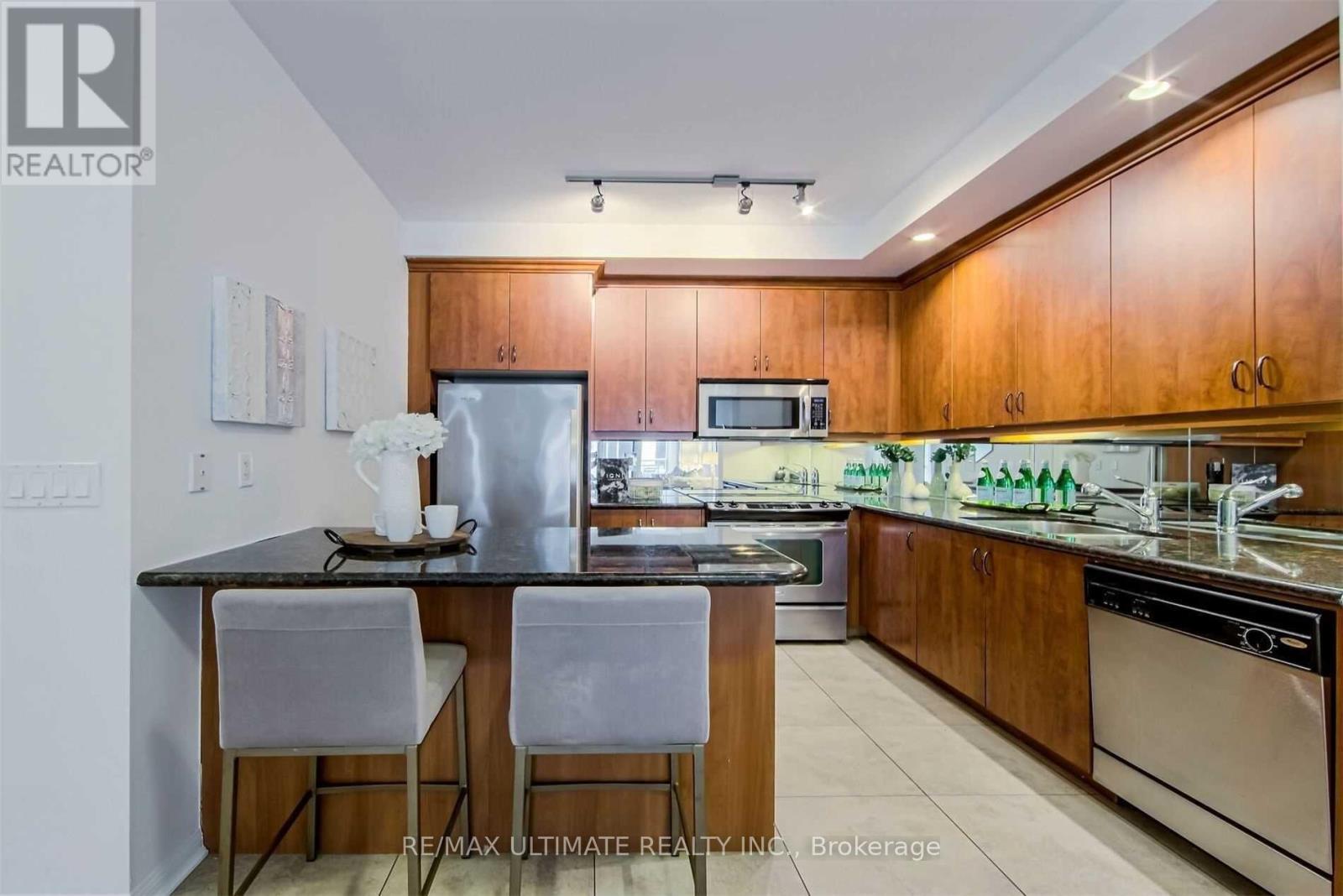 A modern kitchen with wooden cabinets and stainless steel appliances.
