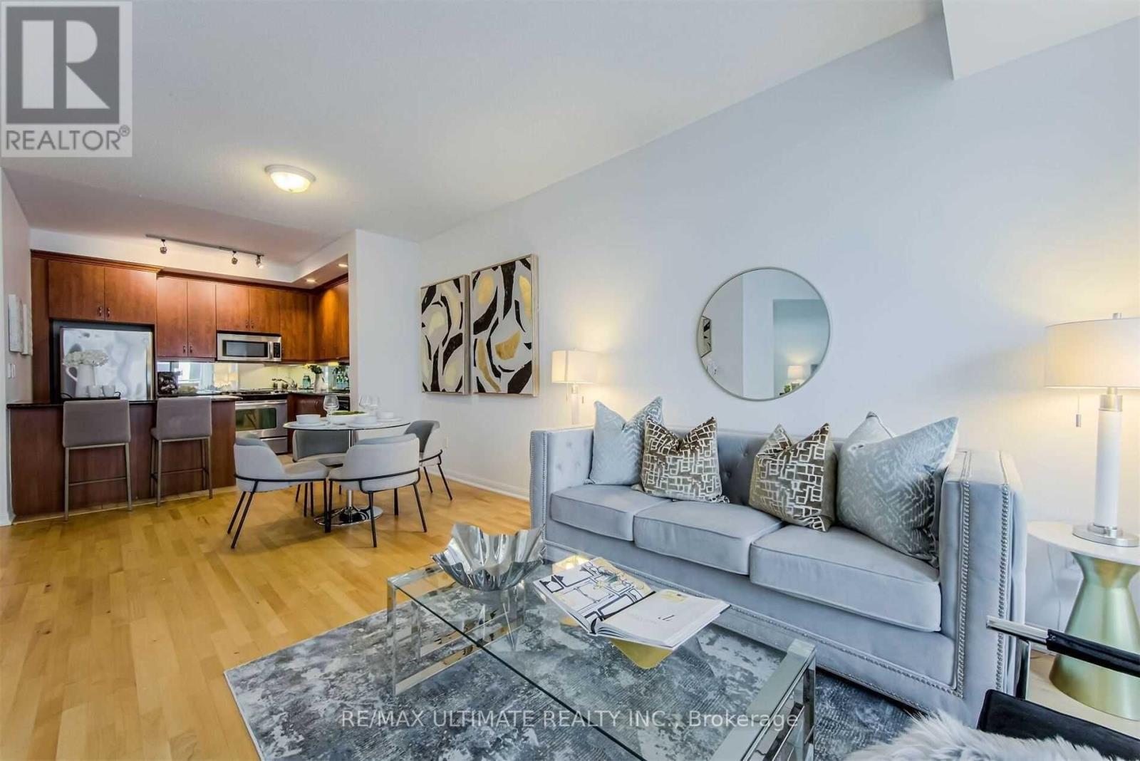 A modern living room with a grey sofa and a glass coffee table.