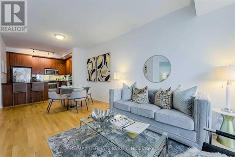 A modern living room with a grey sofa and a glass coffee table.