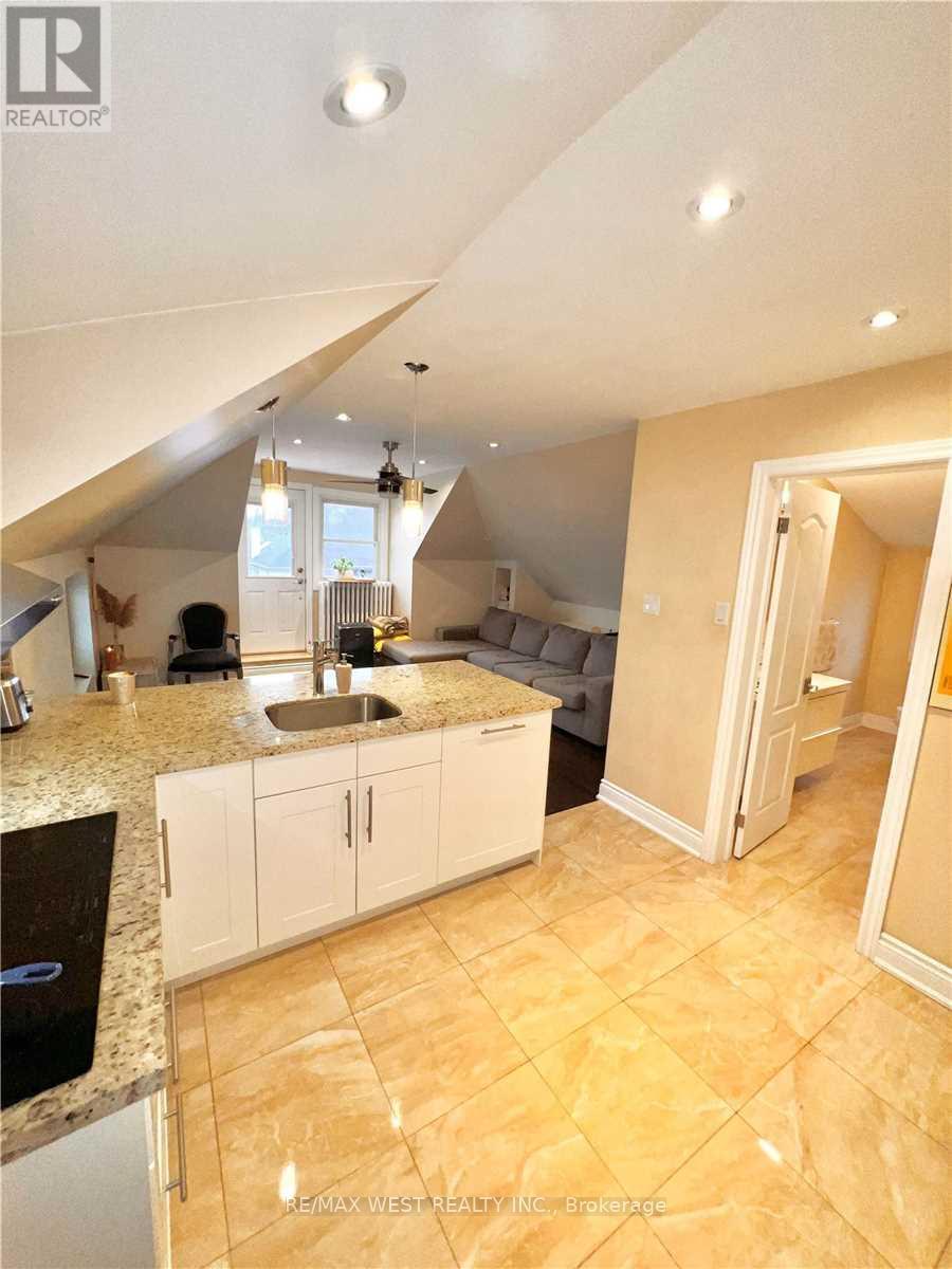 A kitchen with a sink and cabinets under a window.