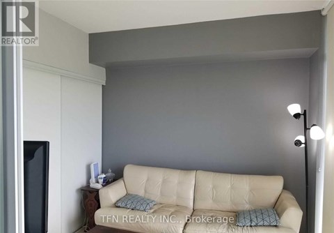 A living room with a beige couch and a television.